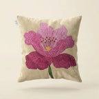 Decorative pillow with a pink flower design on a beige background