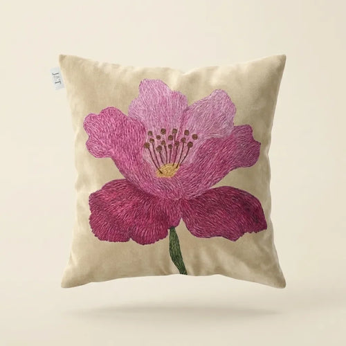 Decorative pillow with a pink flower design on a beige background